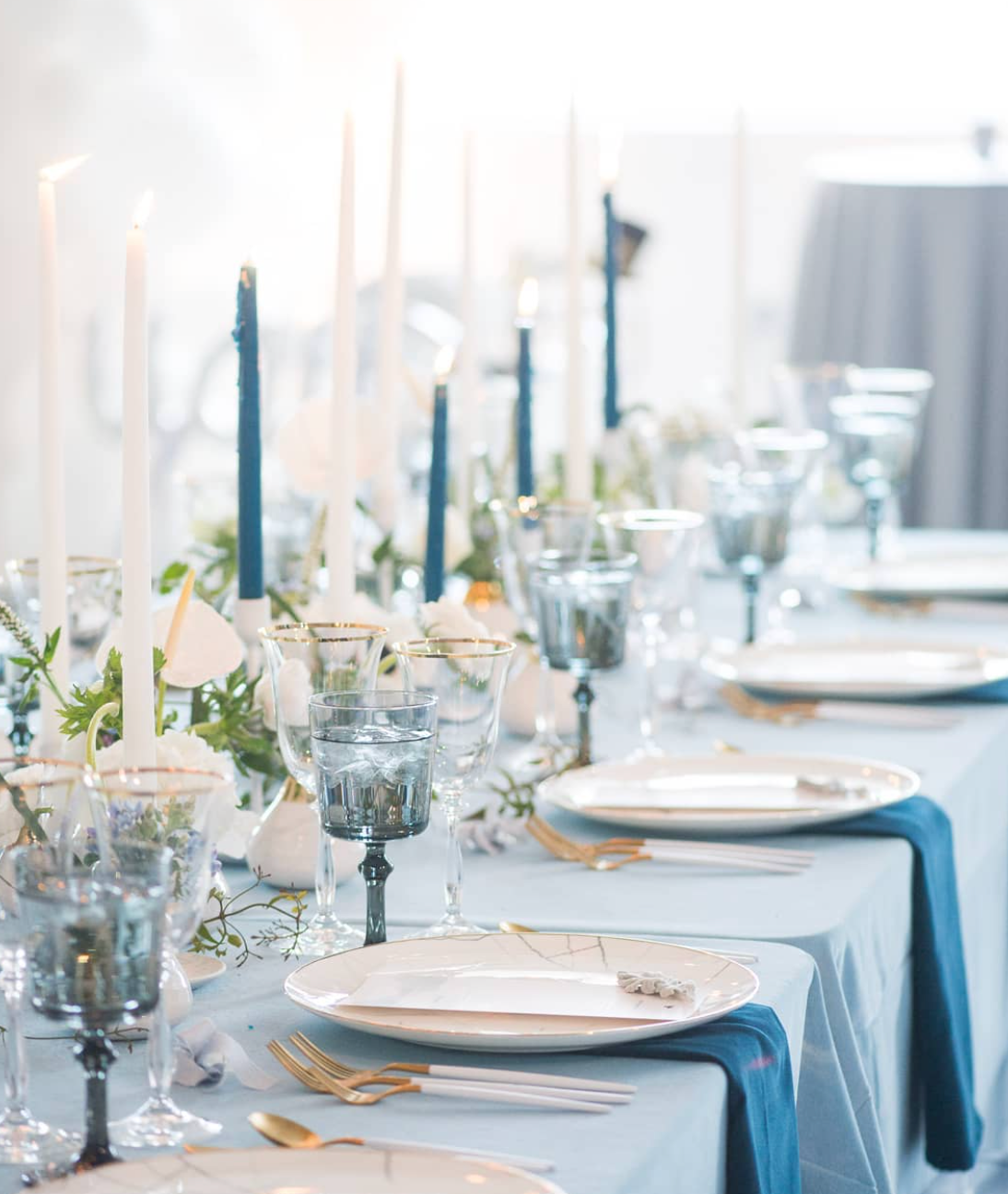 Smoke glass goblets styled on an elegant wedding reception table with candlelight and floral arrangements