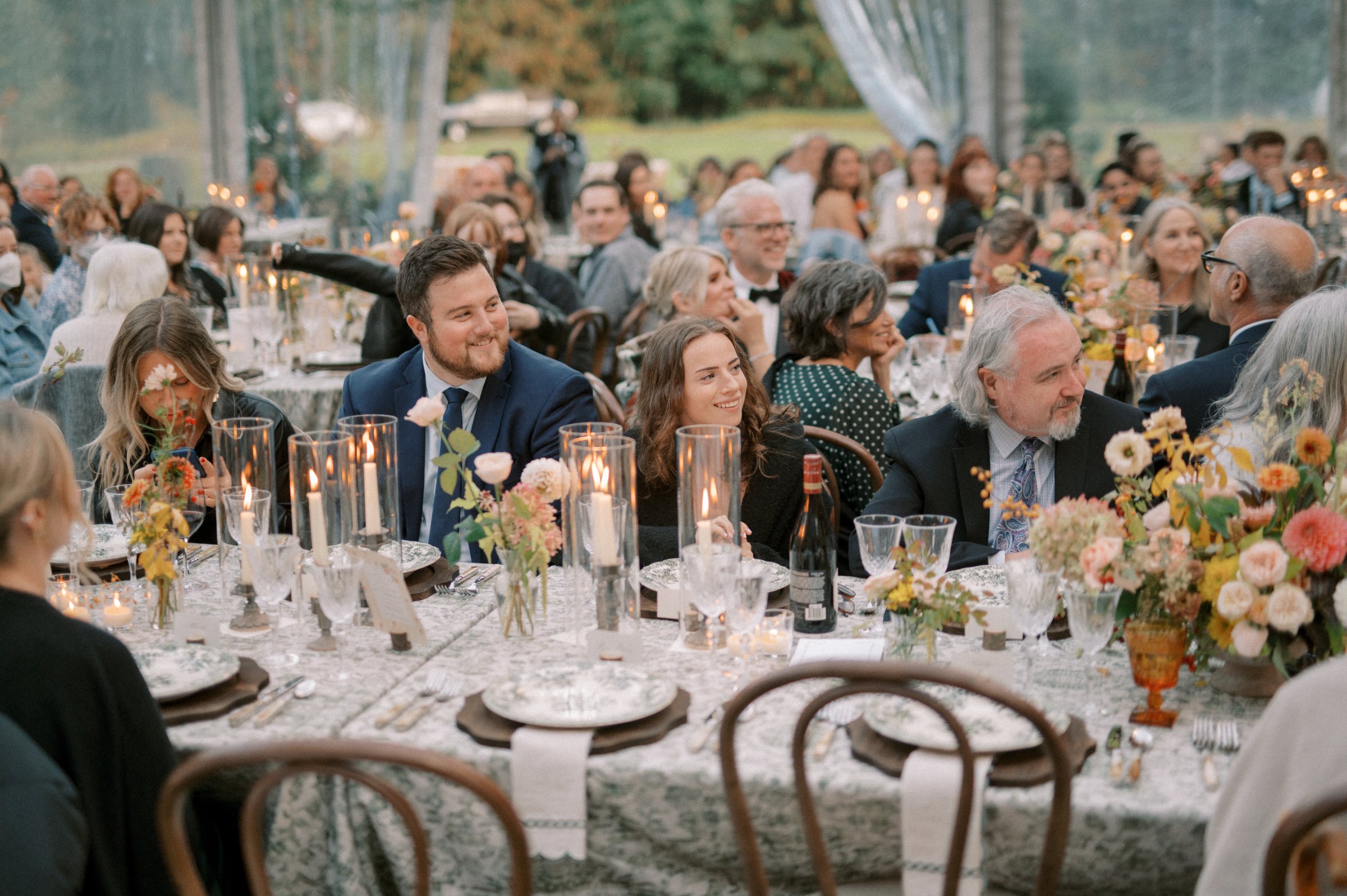 Crystal red wine glasses featured at an outdoor mountain wedding reception at Ryder Lake, British Columbia, with candlelit tables and guests celebrating.
