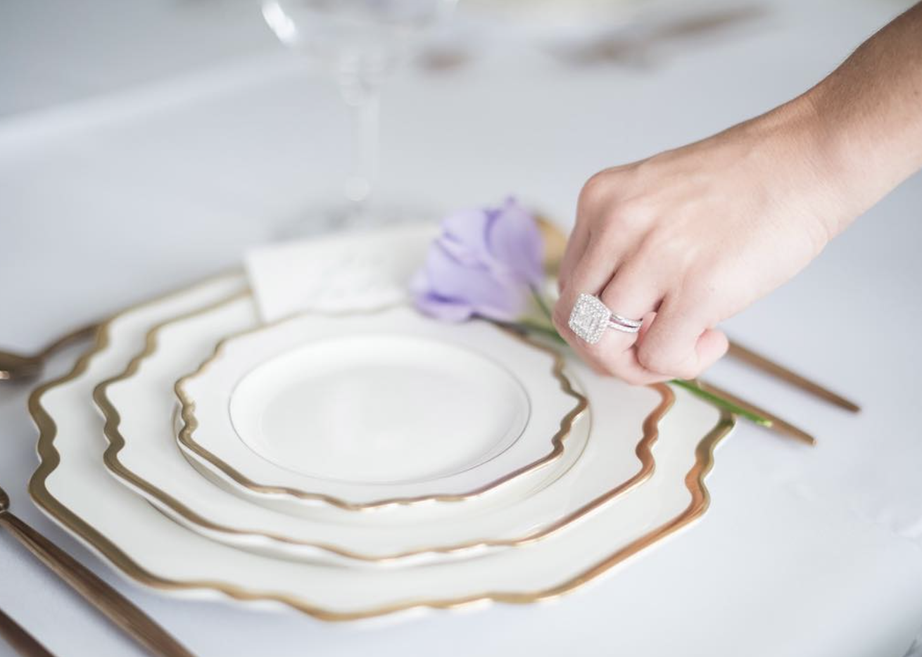 Anna Weatherly white and gold dinner plates styled on an elegant wedding reception table
