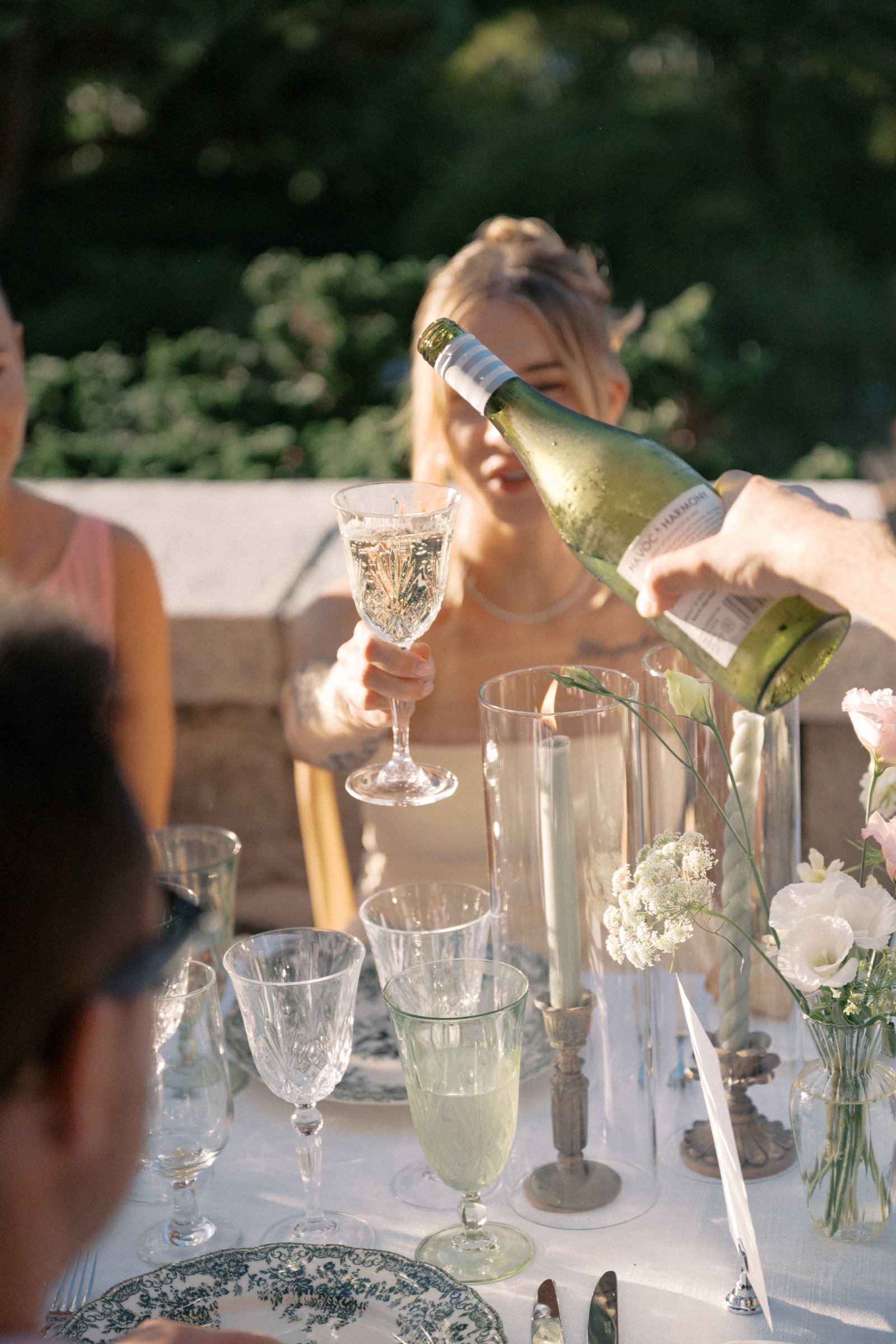 Crystal red wine glasses featured during an outdoor wedding reception toast at Cecil Green Park House in Vancouver, British Columbia.