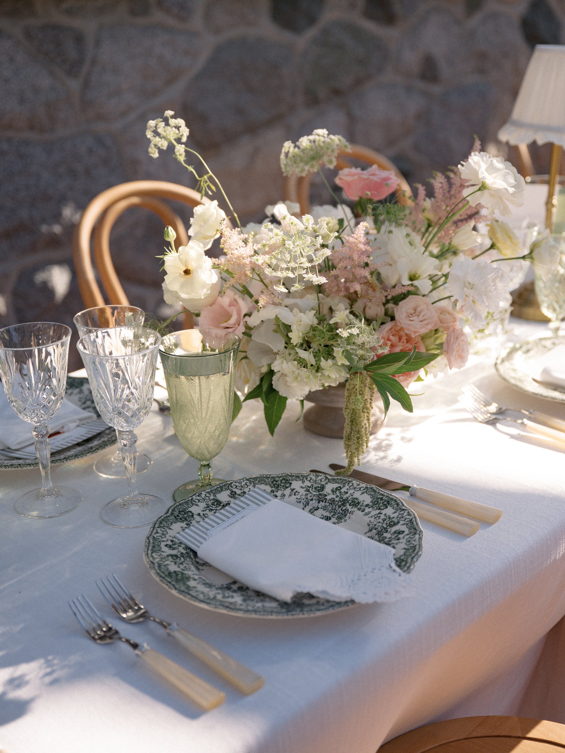 Green cut crystal water goblet styled on a romantic outdoor garden wedding tablescape with layered florals, vintage-inspired dinnerware, and elegant reception décor.