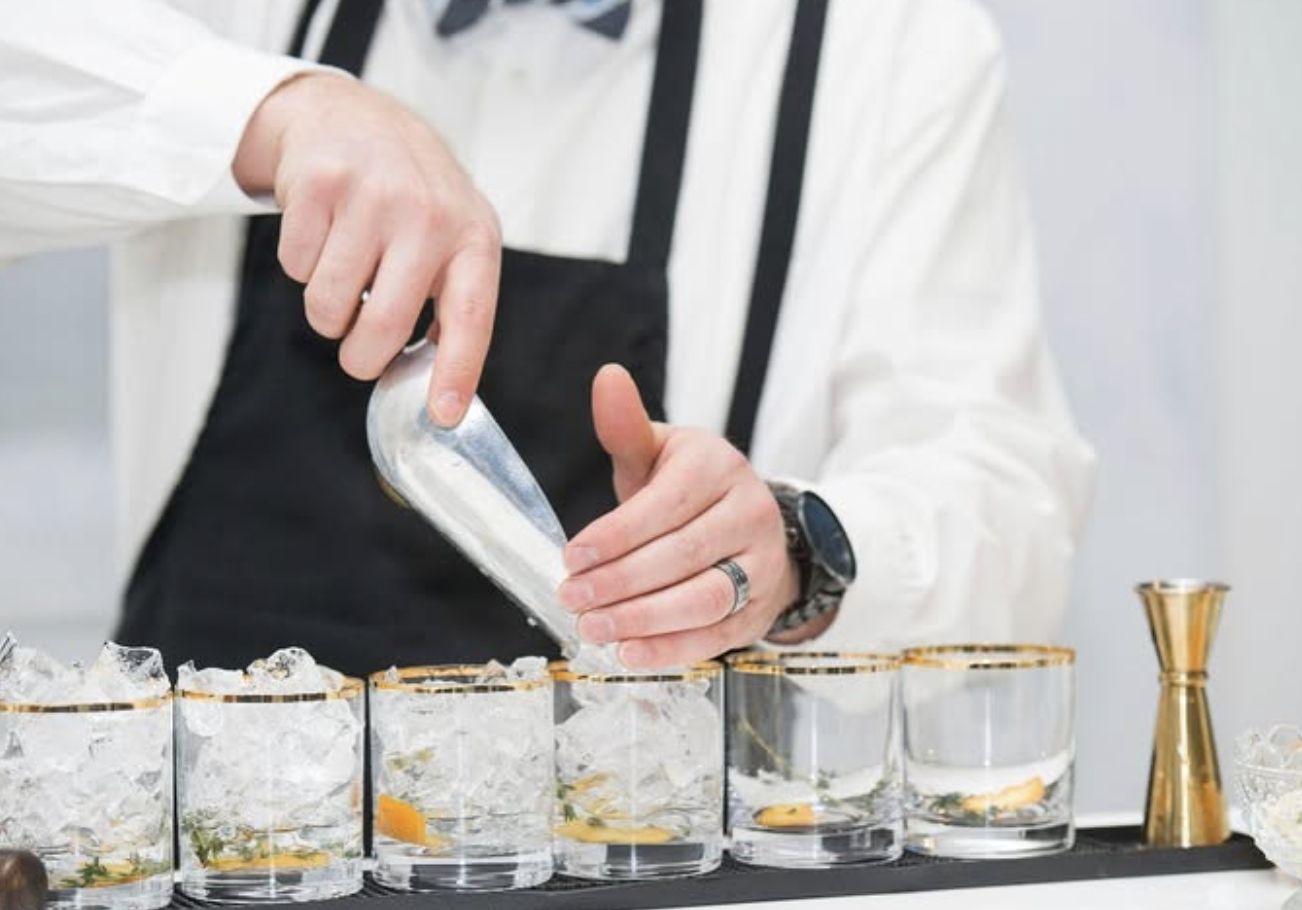 Gold rimmed low ball glasses styled for an elegant wedding bar and cocktail reception