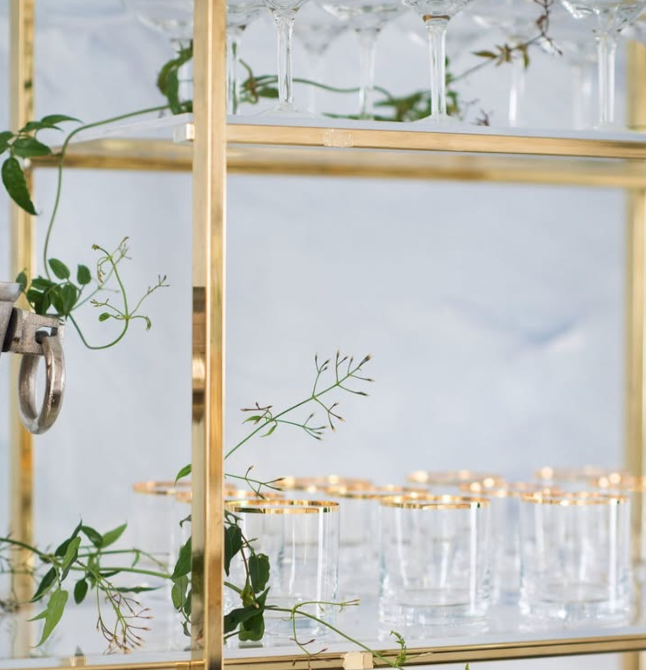 Gold rimmed low ball glasses styled for an elegant wedding bar and cocktail reception