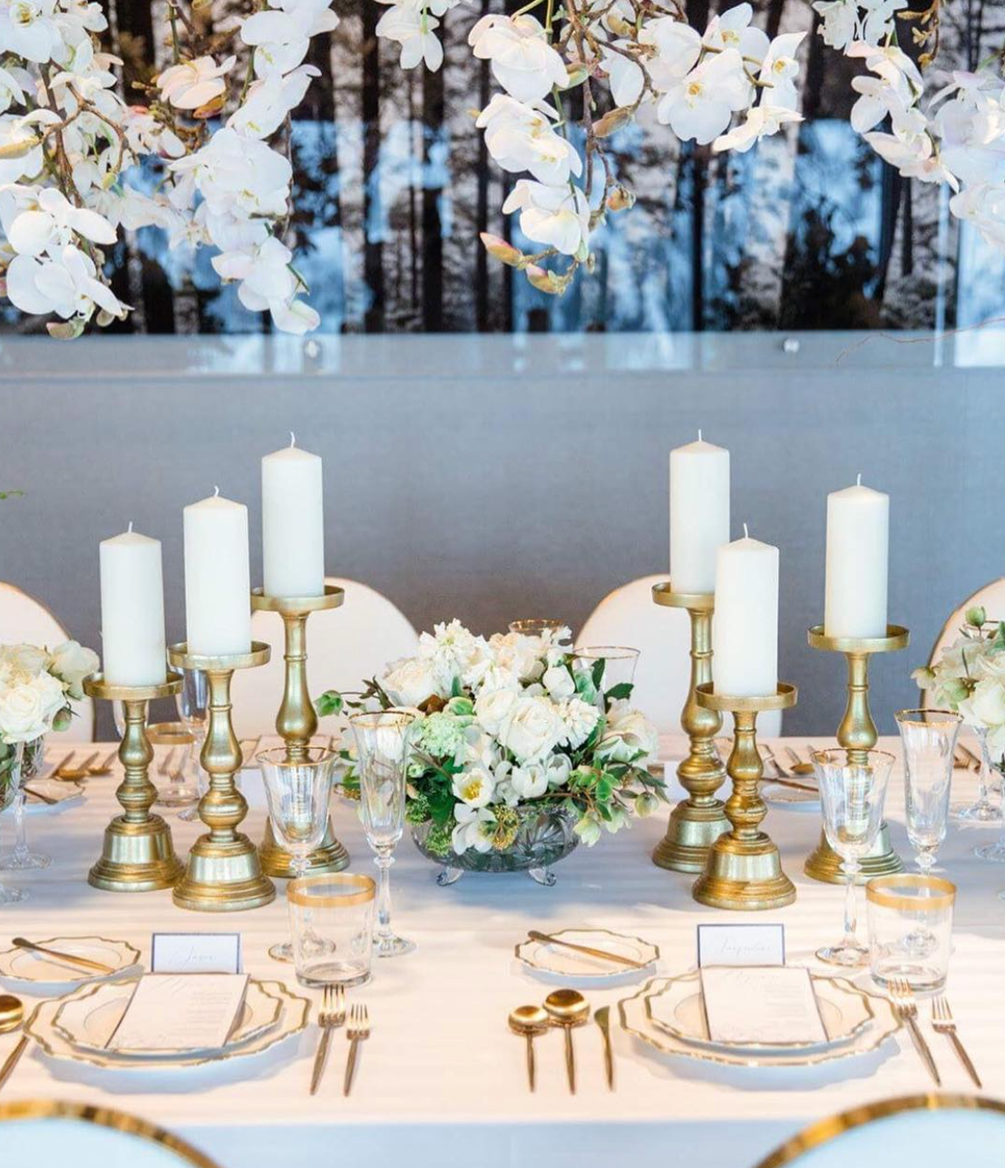 Gold Rimmed Red Wine Glasses styled beside white florals and elegant gold-rimmed dinnerware for a luxury wedding reception.