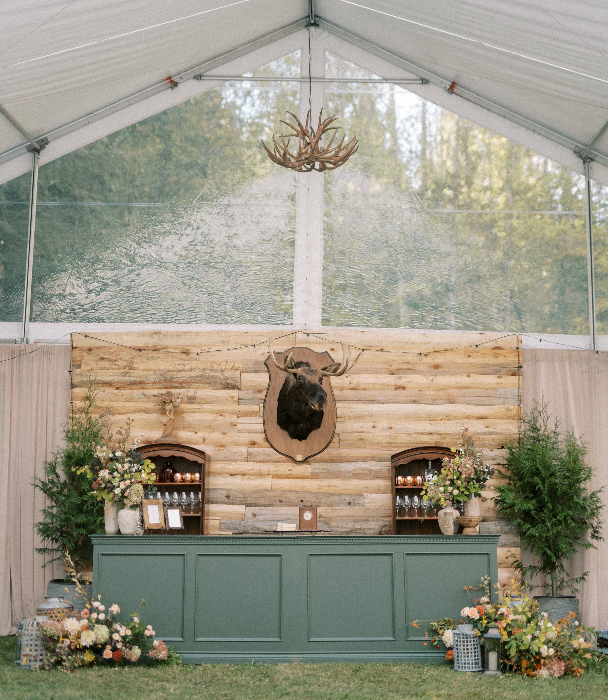 White estate garden bar styled with floral arrangements at an outdoor wedding reception