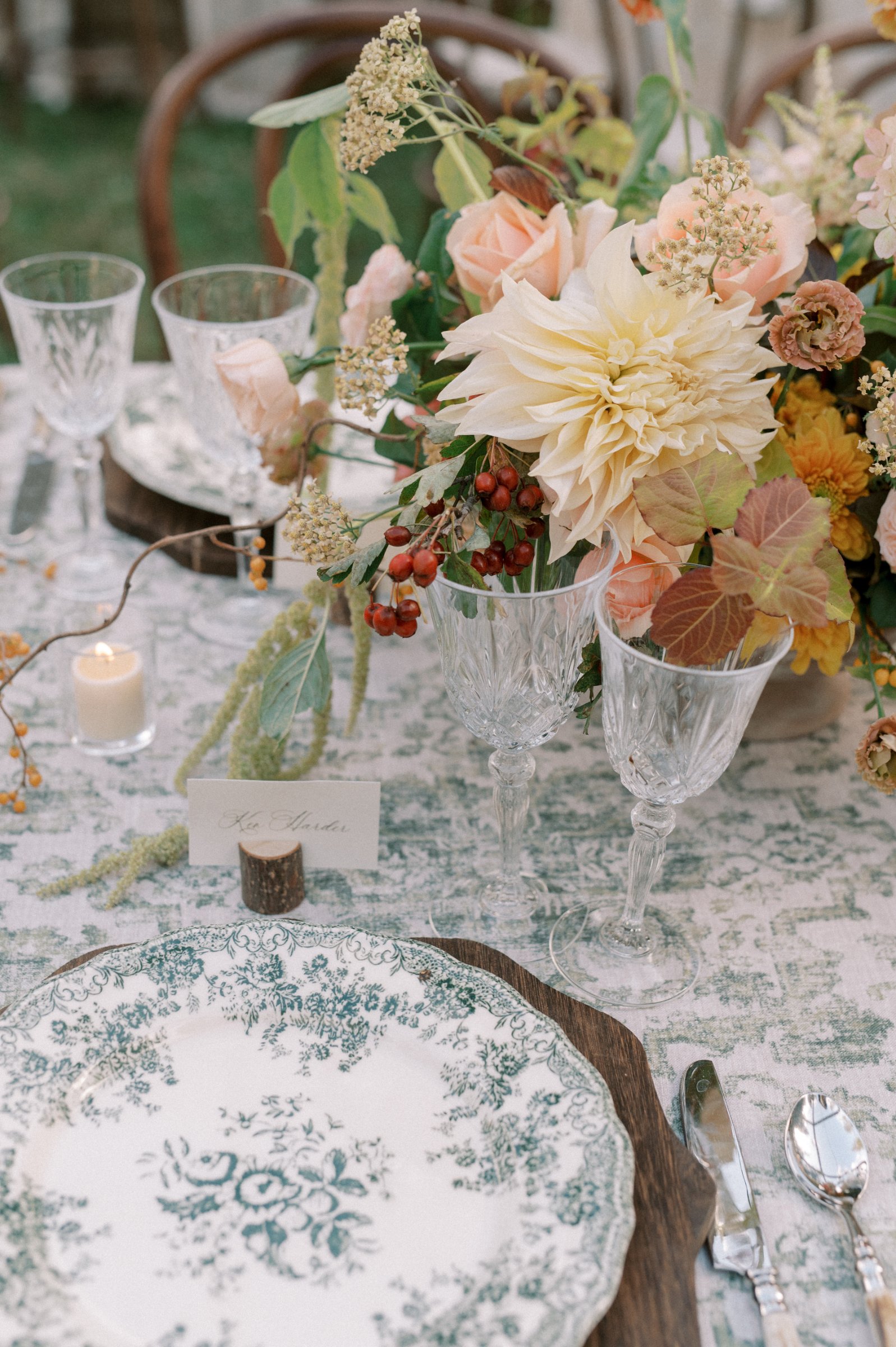 Crystal red wine glasses styled on an elegant wedding reception table with layered place settings, seasonal florals, candlelight, and fine linens.