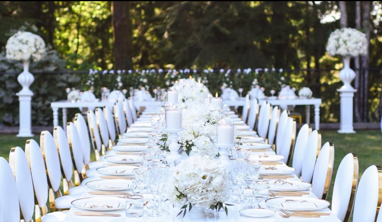 Long estate wedding table styled with Brushed Gold Coupe Chargers, crystal stemware, white florals, and gold flatware